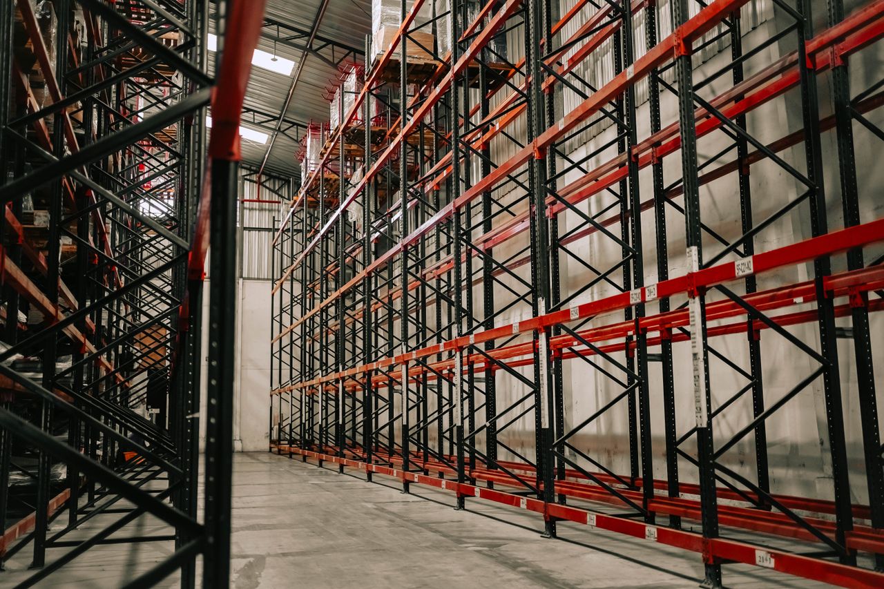 The Art of Drawing Readers In: Your attractive post title goes here Spacious warehouse interior featuring empty metal racks and high ceiling.