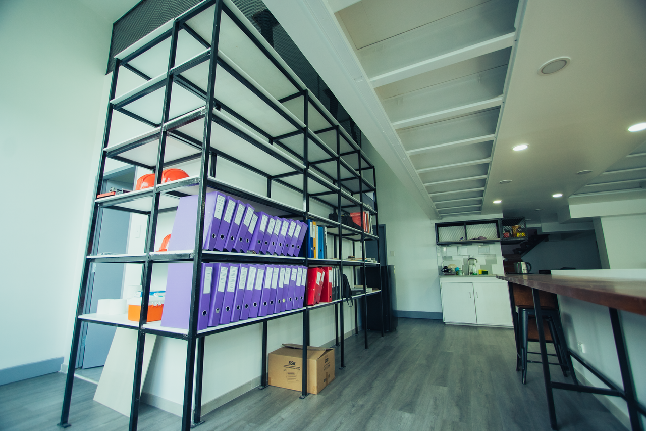 Crafting Captivating Headlines: Your awesome post title goes here Spacious office interior featuring metal shelving with organized binders and kitchen area.