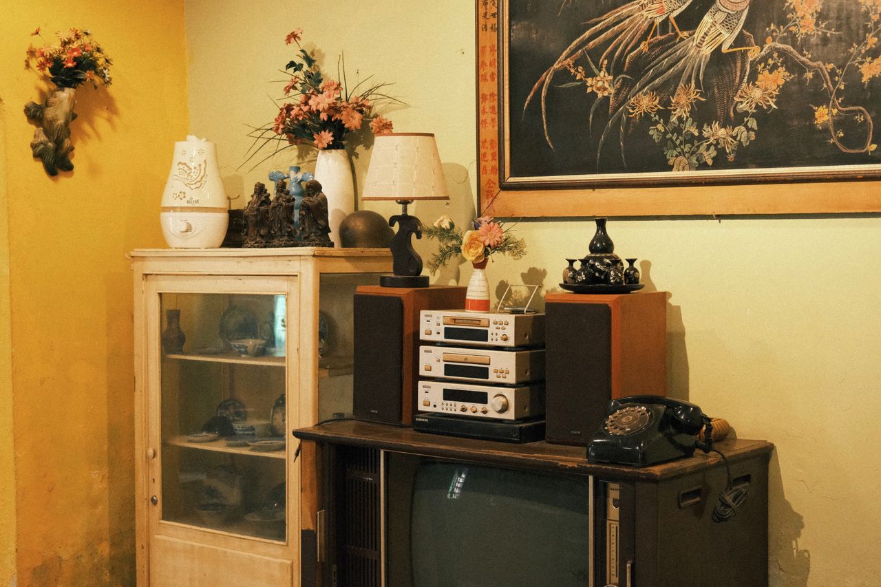services-02 A cozy vintage living room setup featuring retro electronics and artful decor in warm tones.